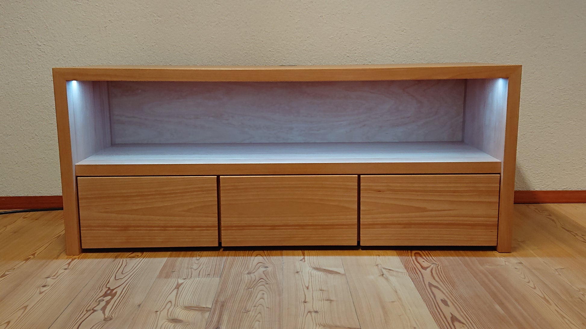 Nahaufnahme der integrierten LED-Beleuchtung im mittleren Fach des Lowboards „Wien“