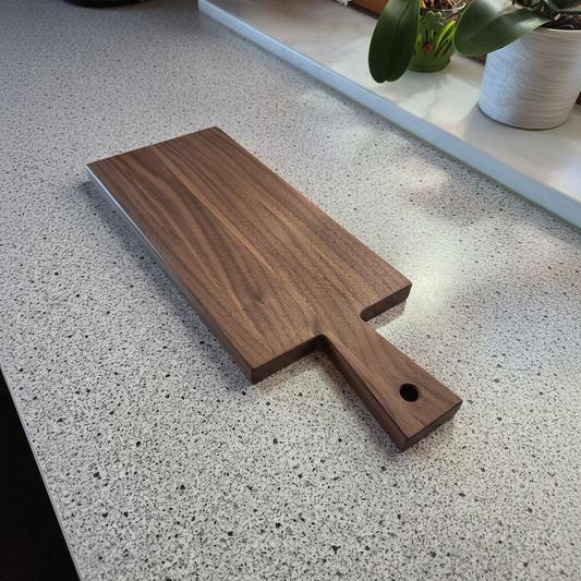 Vesperbrett „Elba“ aus Nussbaum mit Käse, Brot und Aufschnitt auf einem Tisch